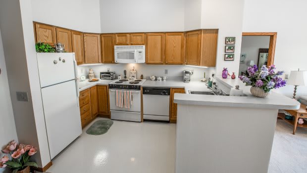 A modern kitchen with wooden cabinets and essential appliances.