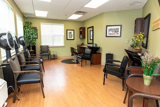 A spacious and inviting waiting room with comfortable chairs, decorative plants, and artwork on the walls.