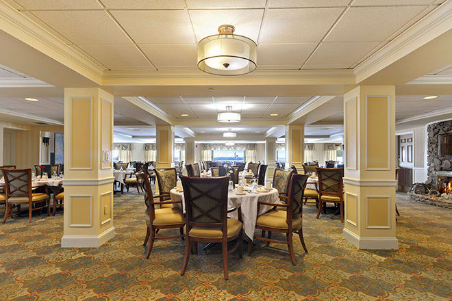 A spacious and elegantly decorated dining room with neatly arranged tables and chairs.