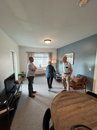 Three individuals engaged in conversation in a well-lit interior space.