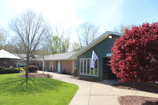 A charming building surrounded by lush greenery and vibrant flowers.