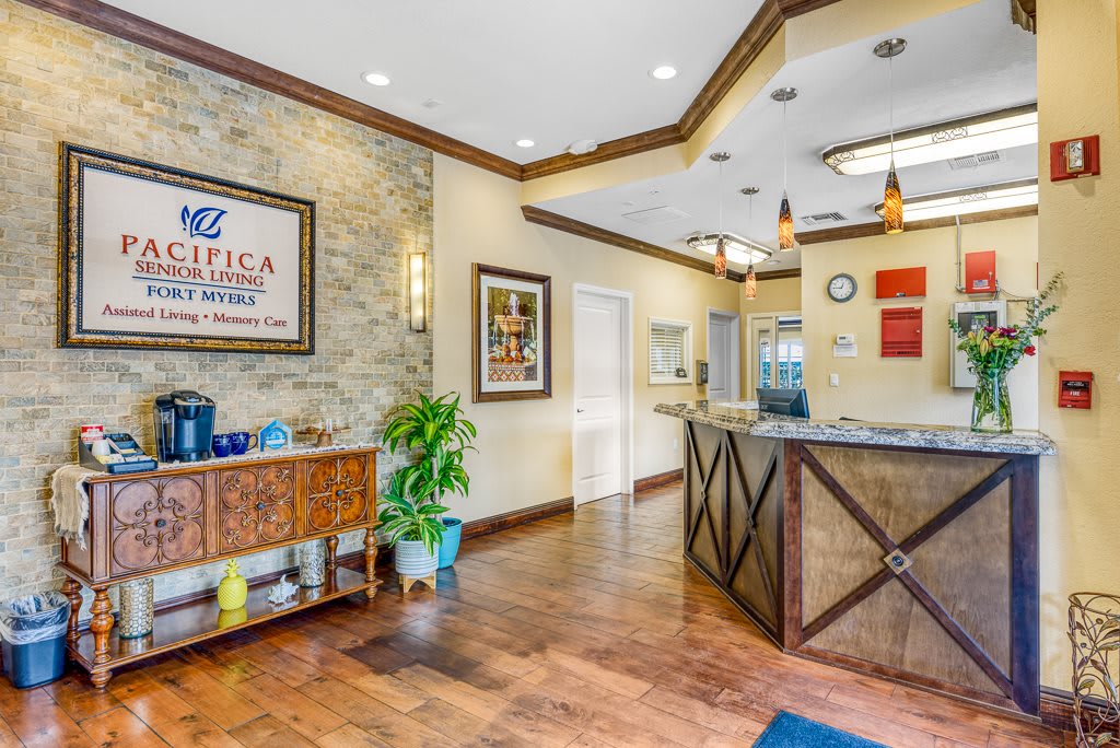 A welcoming reception area with warm wooden floors, decorative artwork, and a front desk.