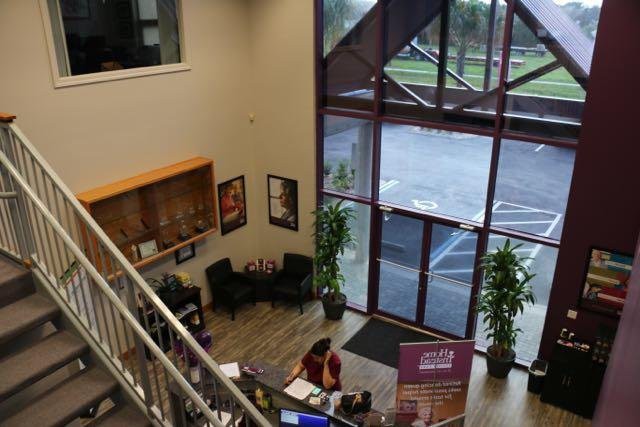 A view of a modern office lobby with a reception desk and waiting area.