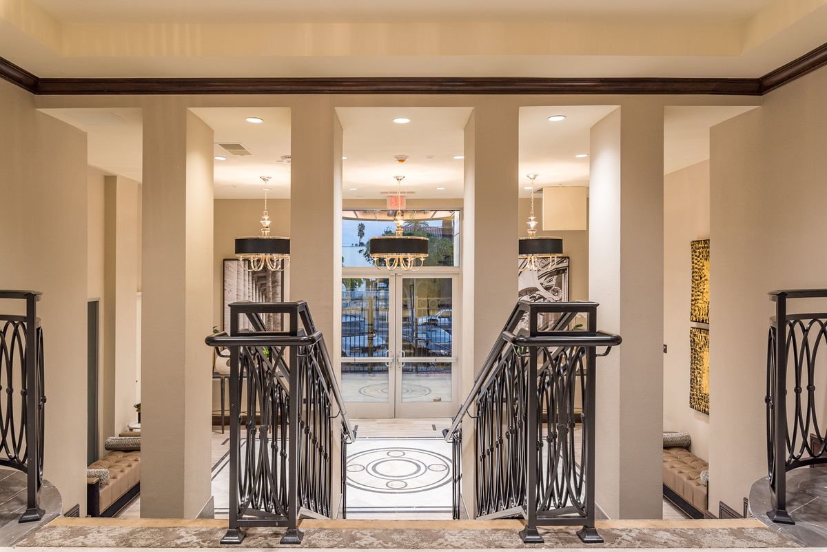 A luxurious interior featuring a grand staircase leading to a well-lit entrance.