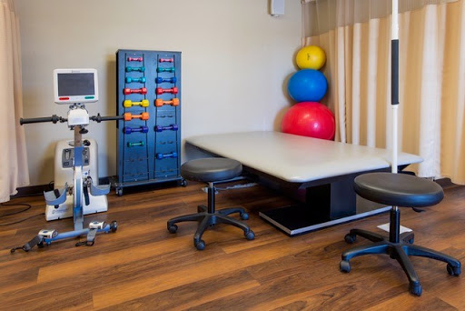 A well-equipped physical therapy room with exercise balls and medical equipment.