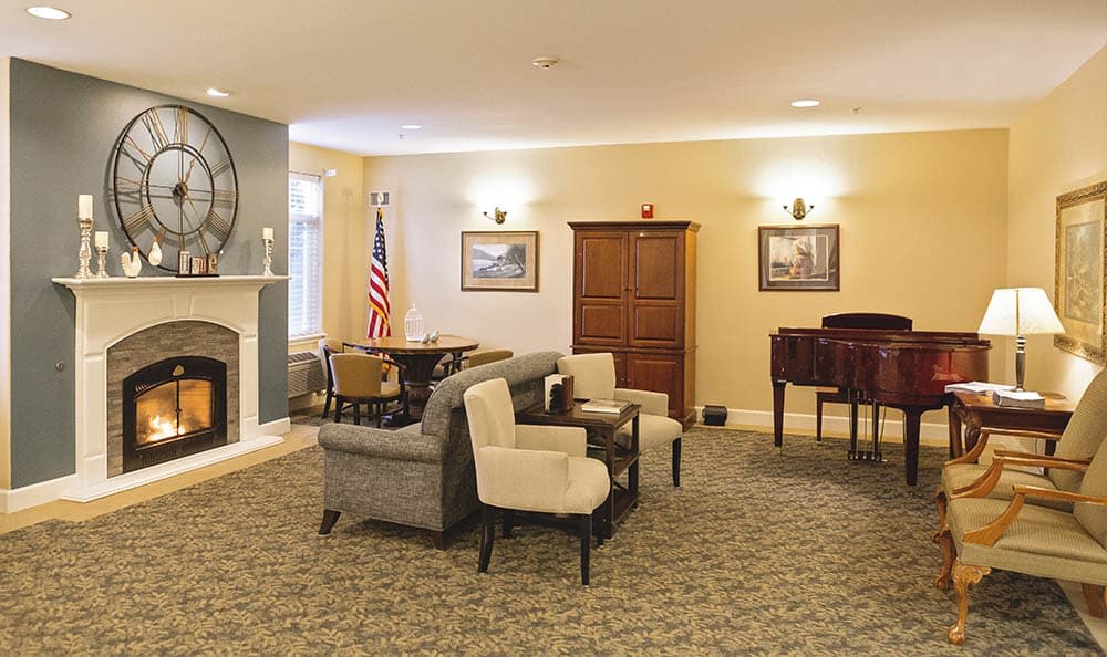 A cozy living room with comfortable seating, a fireplace, and a piano.