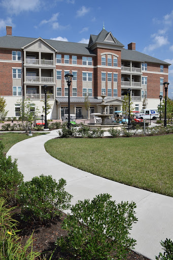 A well-designed residential building with landscaped surroundings and a winding pathway.