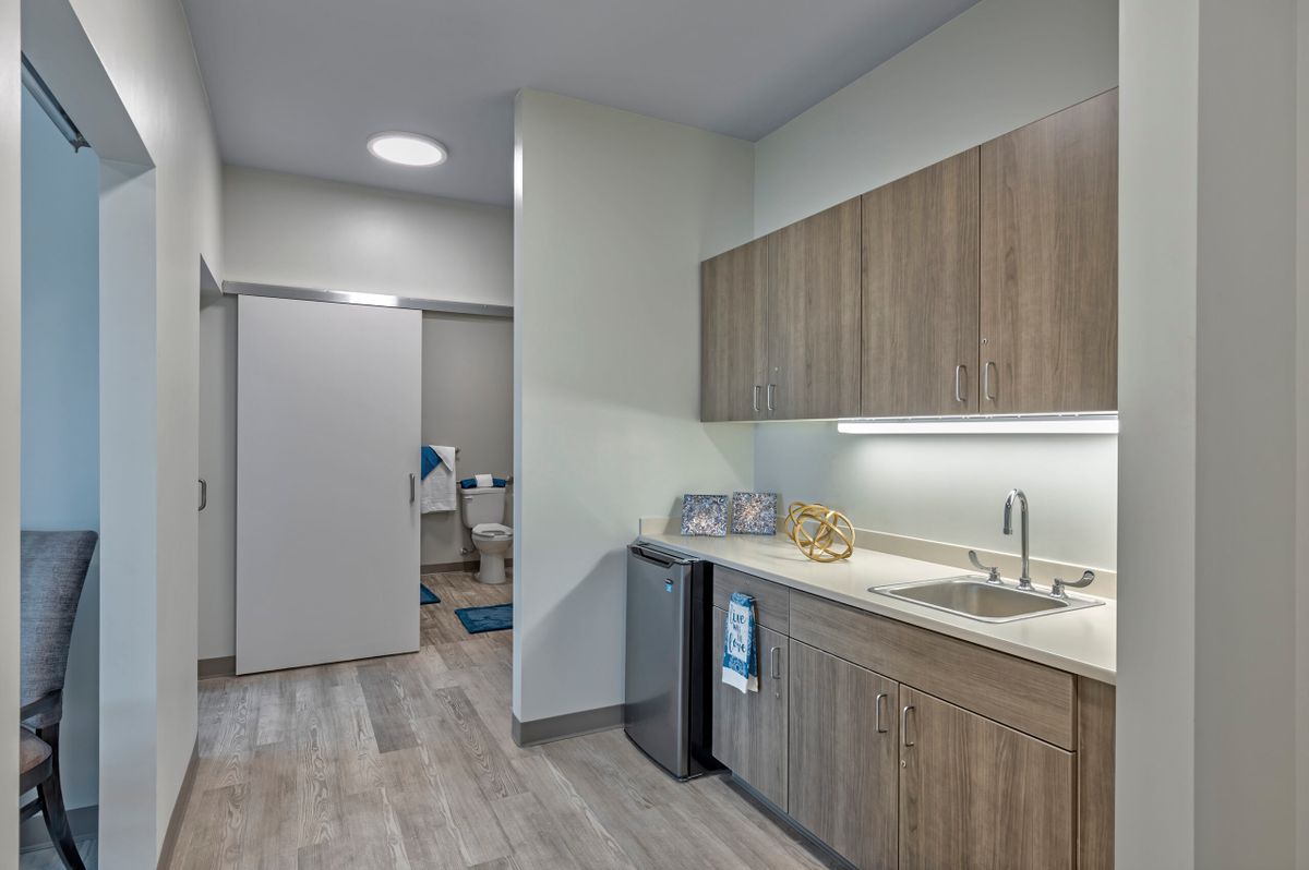 A modern kitchen interior featuring wood cabinets and minimalist design.