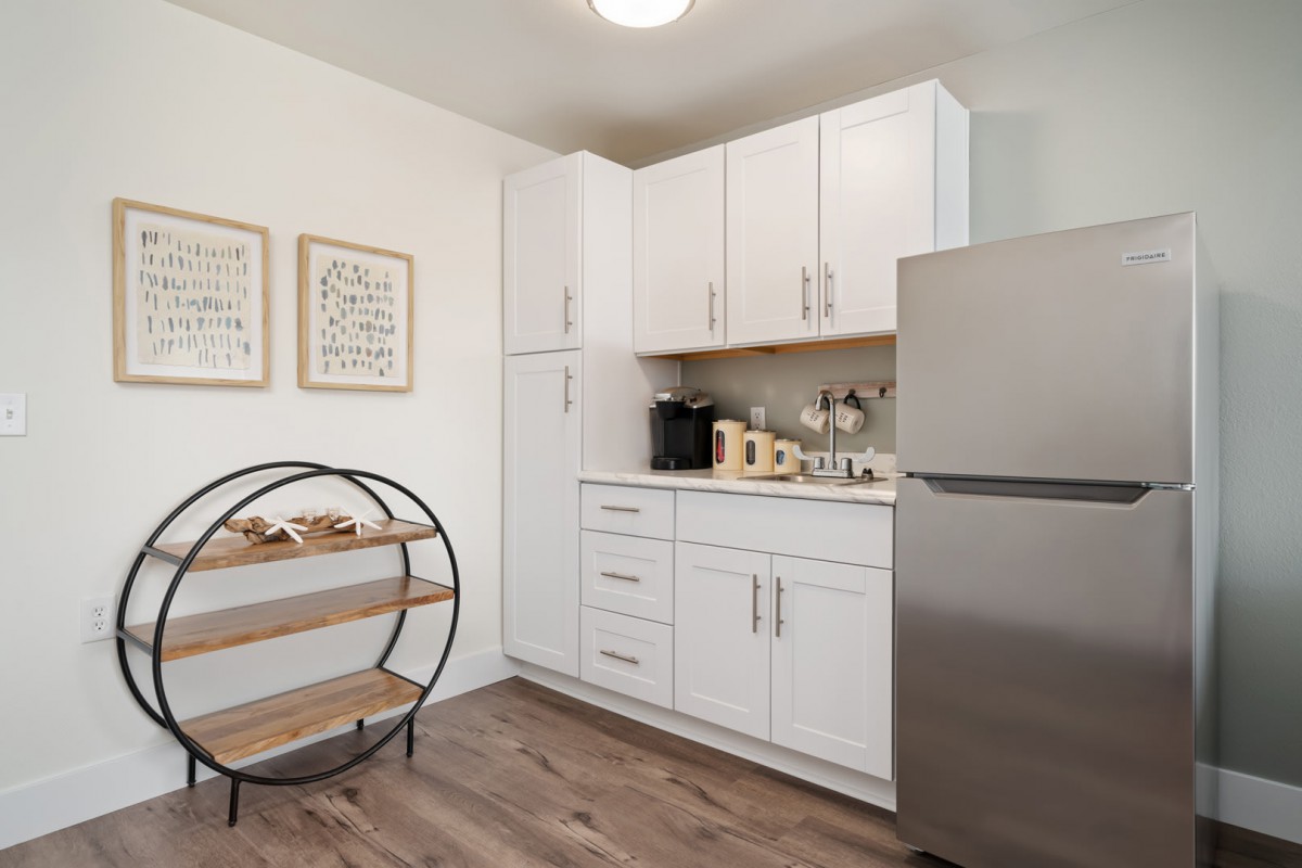 A modern kitchen with white cabinets, stainless steel appliances, and minimalist decor.