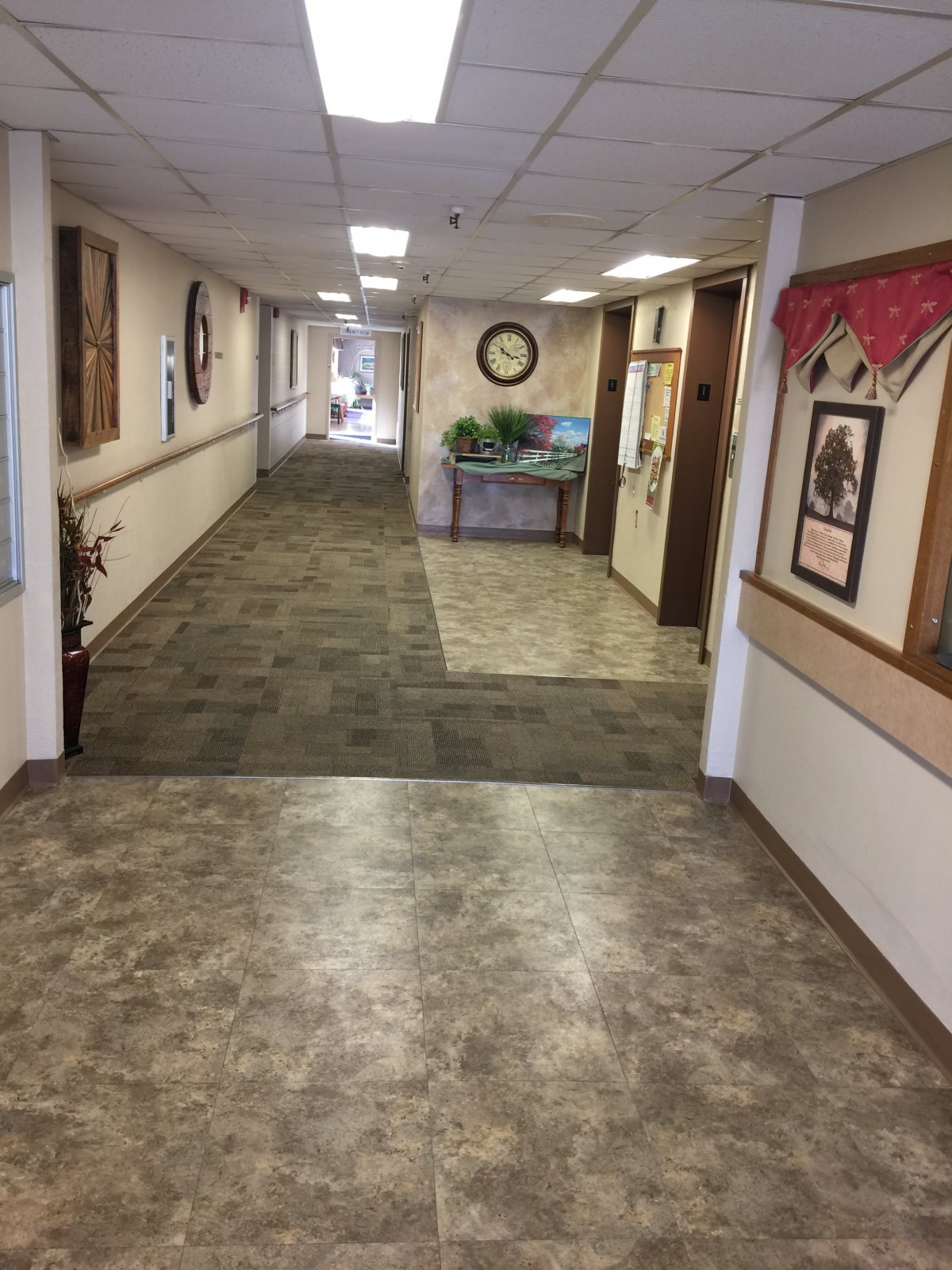 A long hallway with carpeted flooring and wall decorations.