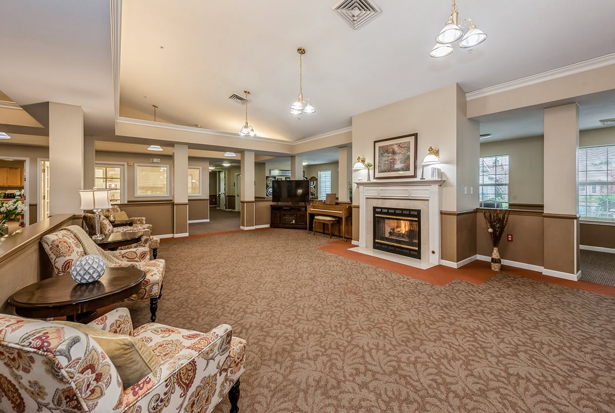 A cozy living room with a fireplace, comfortable seating, and warm lighting.