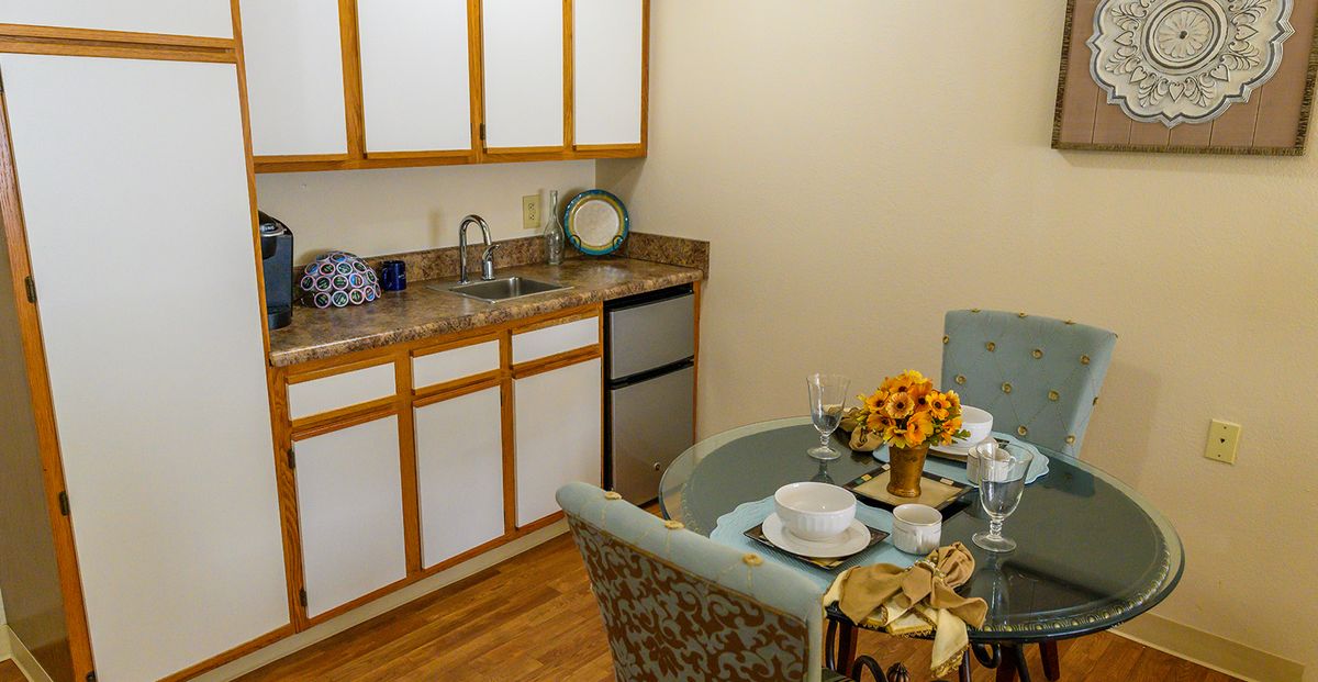 A cozy kitchen and dining area with a table set for two.