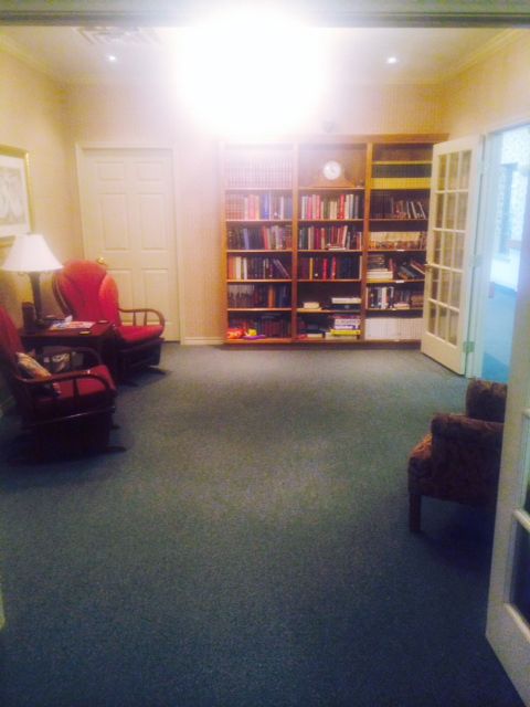 A cozy living room featuring bookshelves and comfortable seating.