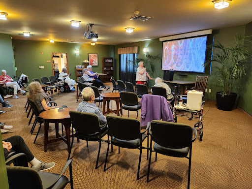 A community gathering where an individual presents to an audience of elderly attendees.