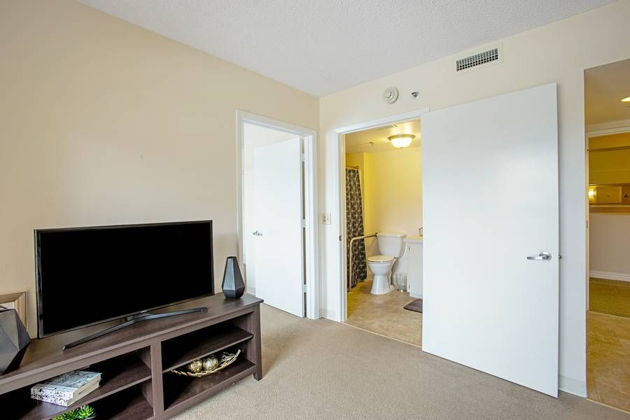 A modern living space with a television and an adjoining bathroom.