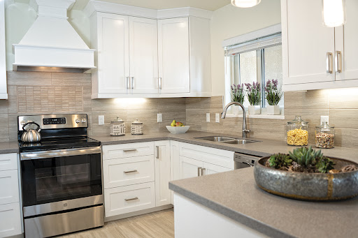 A modern kitchen featuring sleek white cabinets and stainless steel appliances, designed for both functionality and style.