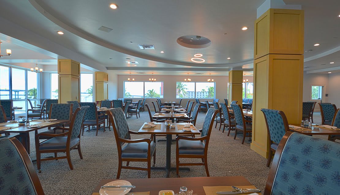 An empty restaurant dining area with neatly arranged tables and chairs.