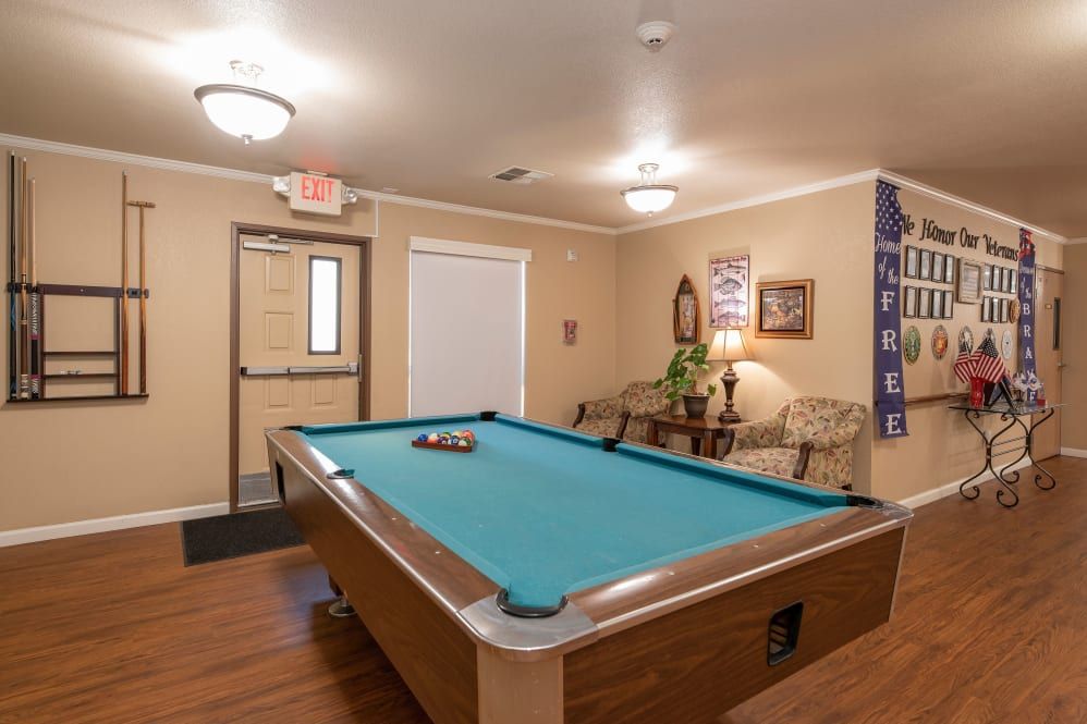 A cozy game room featuring a pool table and comfortable seating.