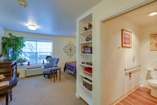 A cozy bedroom with a comfortable seating area and well-organized shelves.