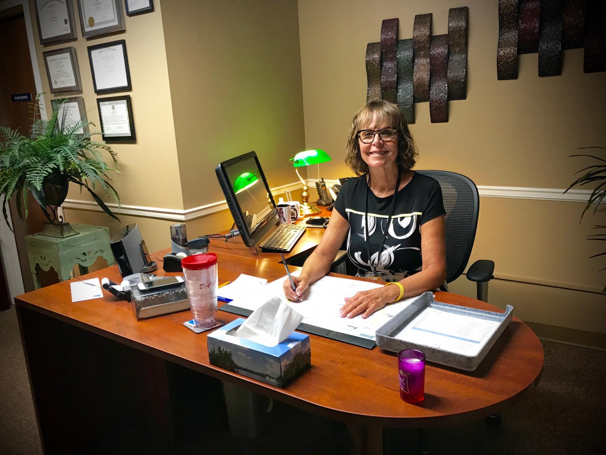 A woman sitting at her desk in a well-organized office setting.