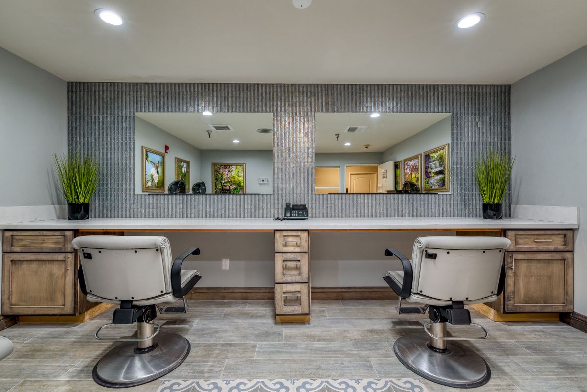 A well-designed barber shop interior with stylish chairs and large mirrors.