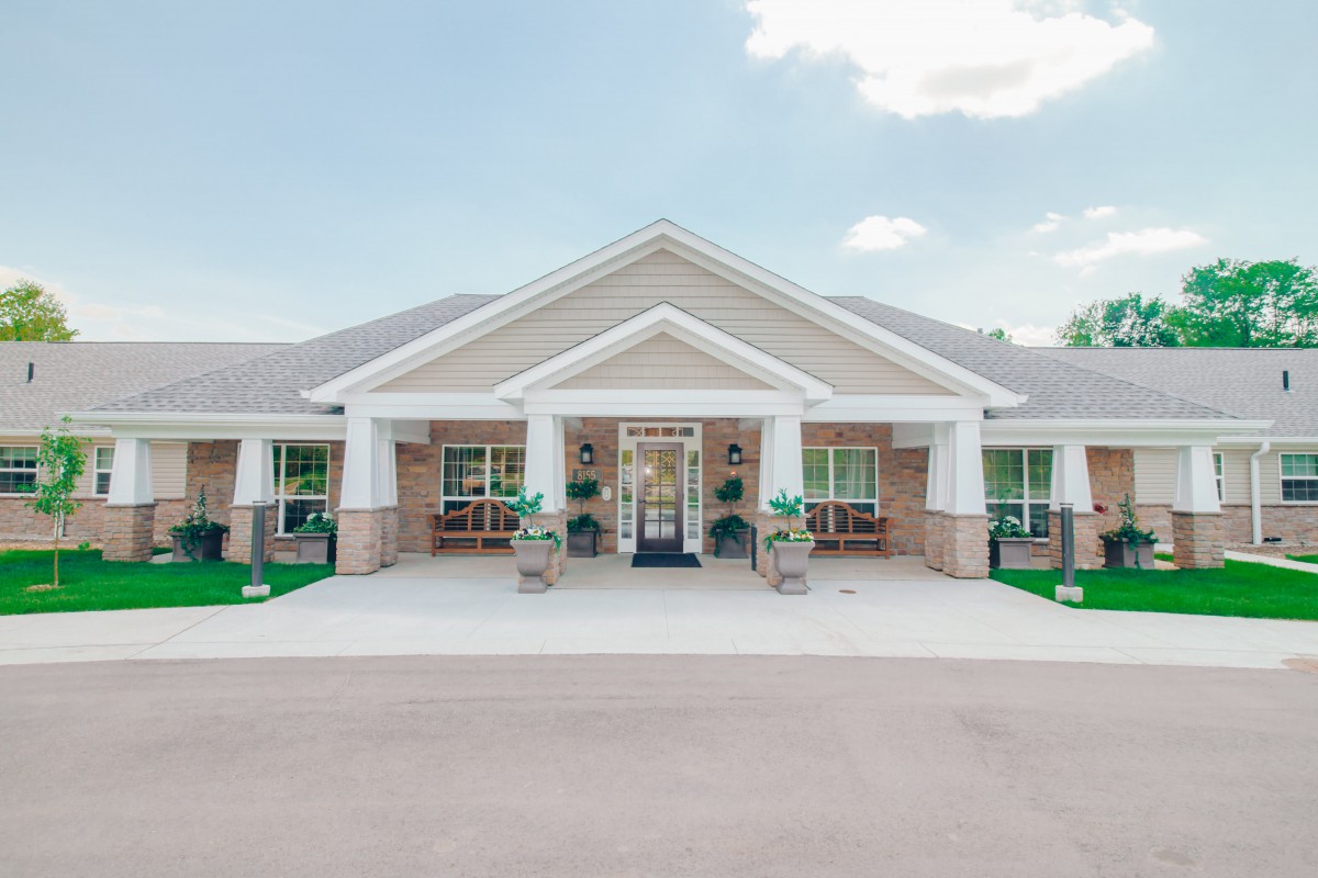 A symmetrical brick building with a prominent entrance and decorative columns.