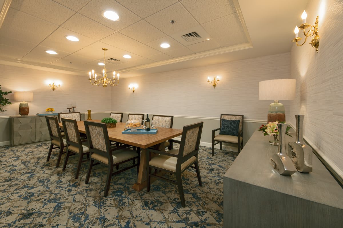 A well-lit dining room with a large table, chairs, and elegant dcor.