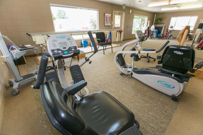 A fitness center featuring various exercise machines in an indoor setting.