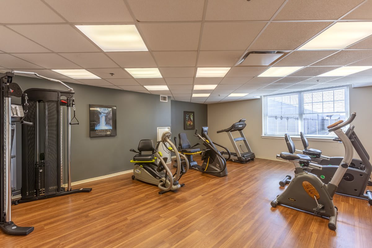 A well-lit gym with various exercise equipment including treadmills and cardio machines.