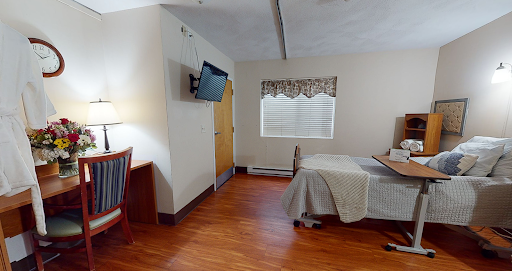 A cozy hotel room featuring a bed, television, and simple furnishings.