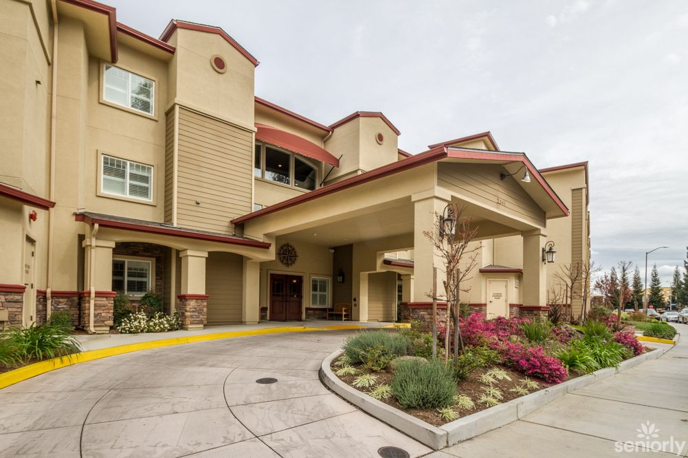 A residential building with a covered entrance and landscaped surroundings.