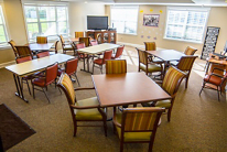A communal dining area with tables and chairs arranged neatly.