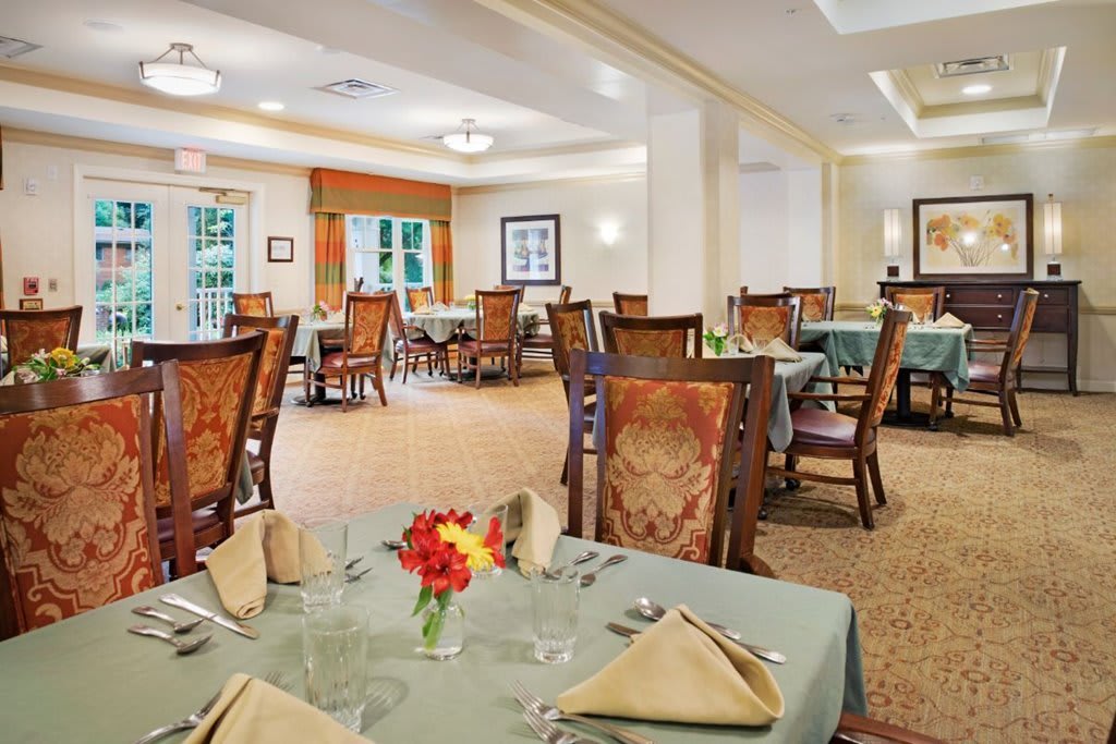 A well-appointed dining room with elegantly set tables and comfortable chairs.