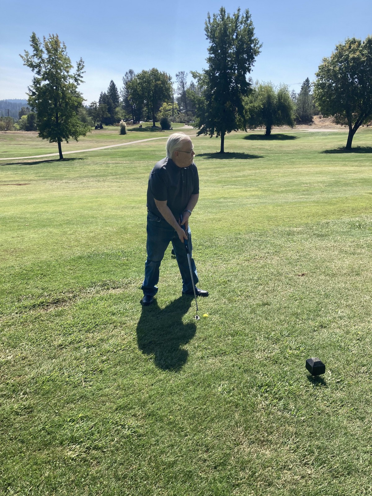 A person preparing to swing a golf club on a sunny day.