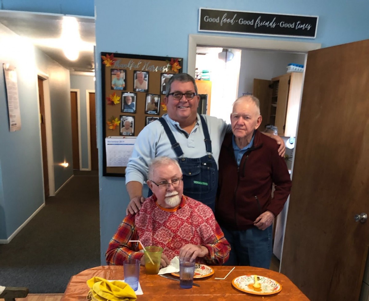 Three men enjoying a meal together in a cozy setting.