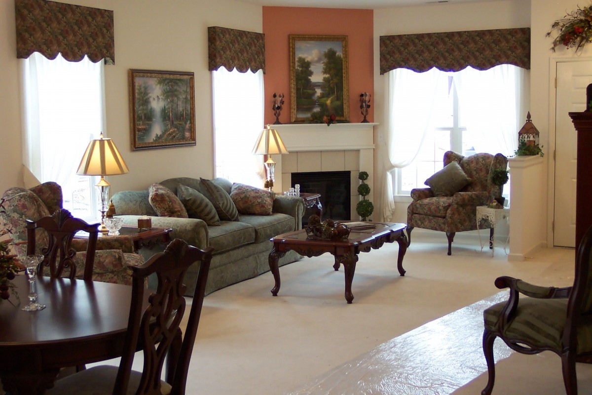 A cozy living room with elegant furniture, including a sofa and armchairs surrounding a fireplace.