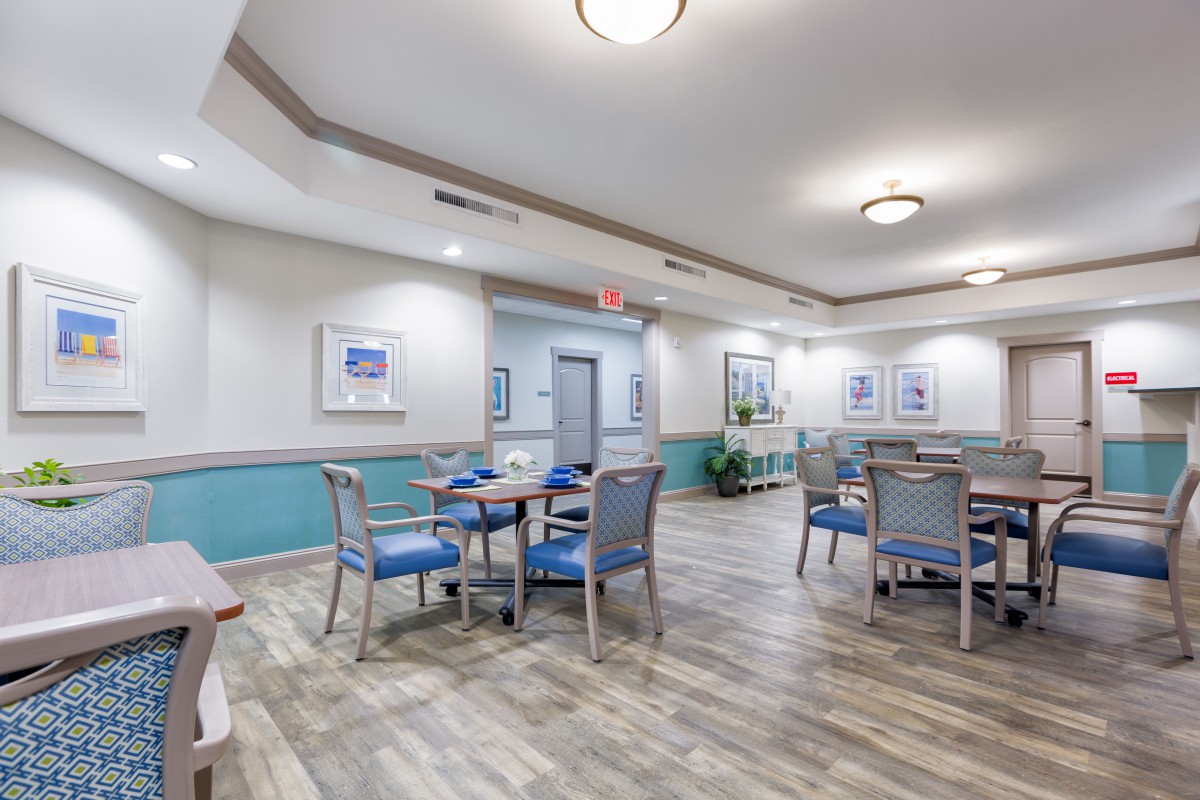 A well-lit dining area with neatly arranged tables and chairs, featuring modern dcor and flooring.