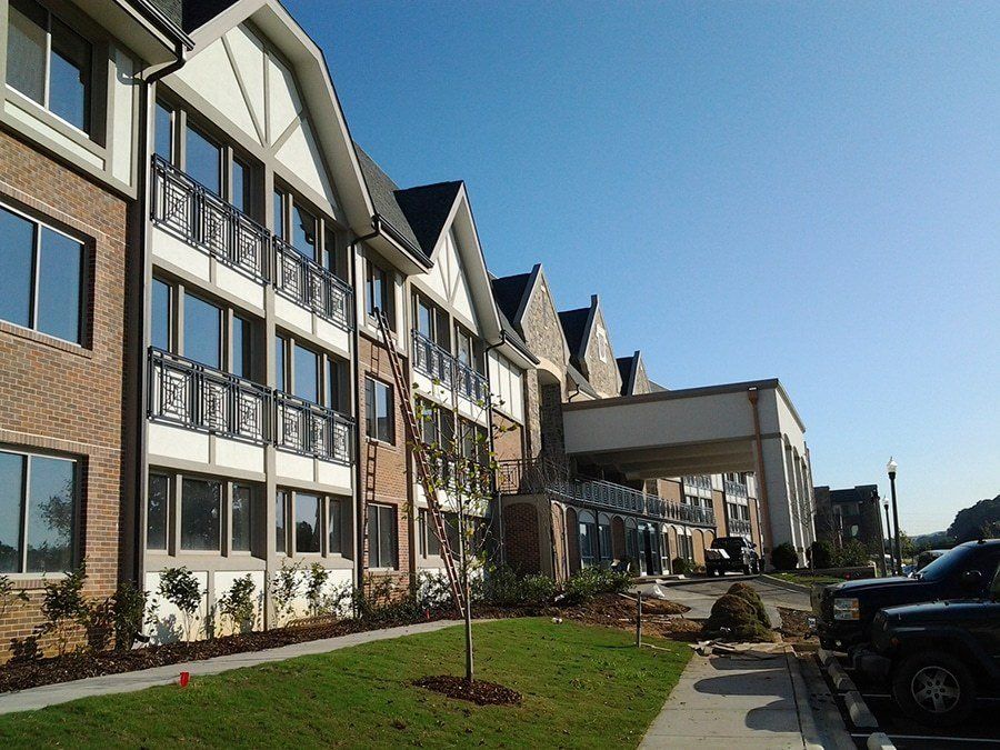 A modern residential building with well-maintained landscaping on a sunny day.