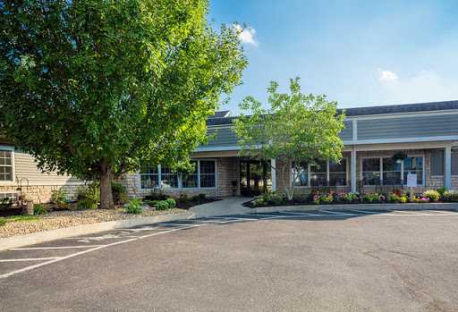 A modern office building surrounded by lush greenery on a sunny day.