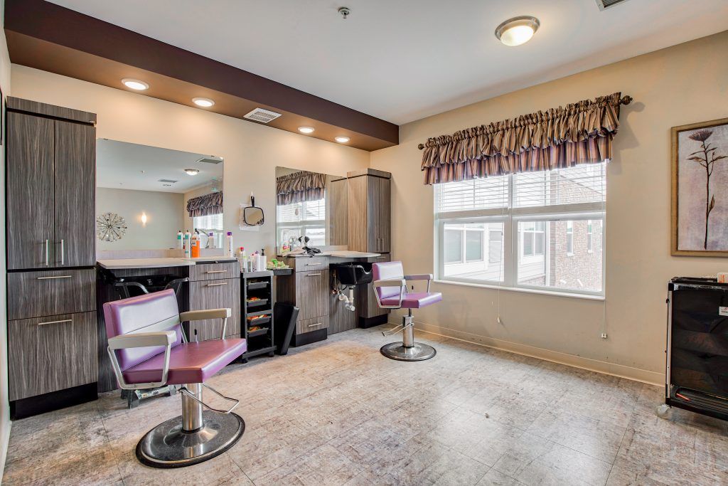 A spacious and well-lit hair salon interior with chairs and mirrors.