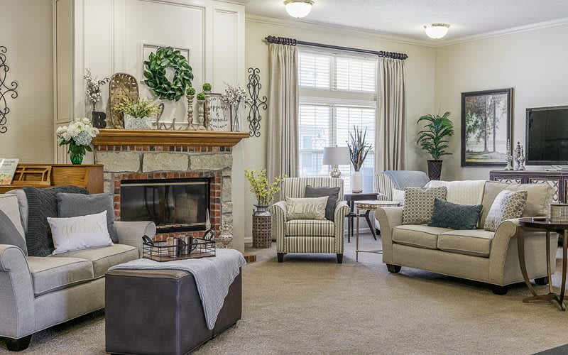 A cozy living room with a fireplace, comfortable seating, and elegant decor.
