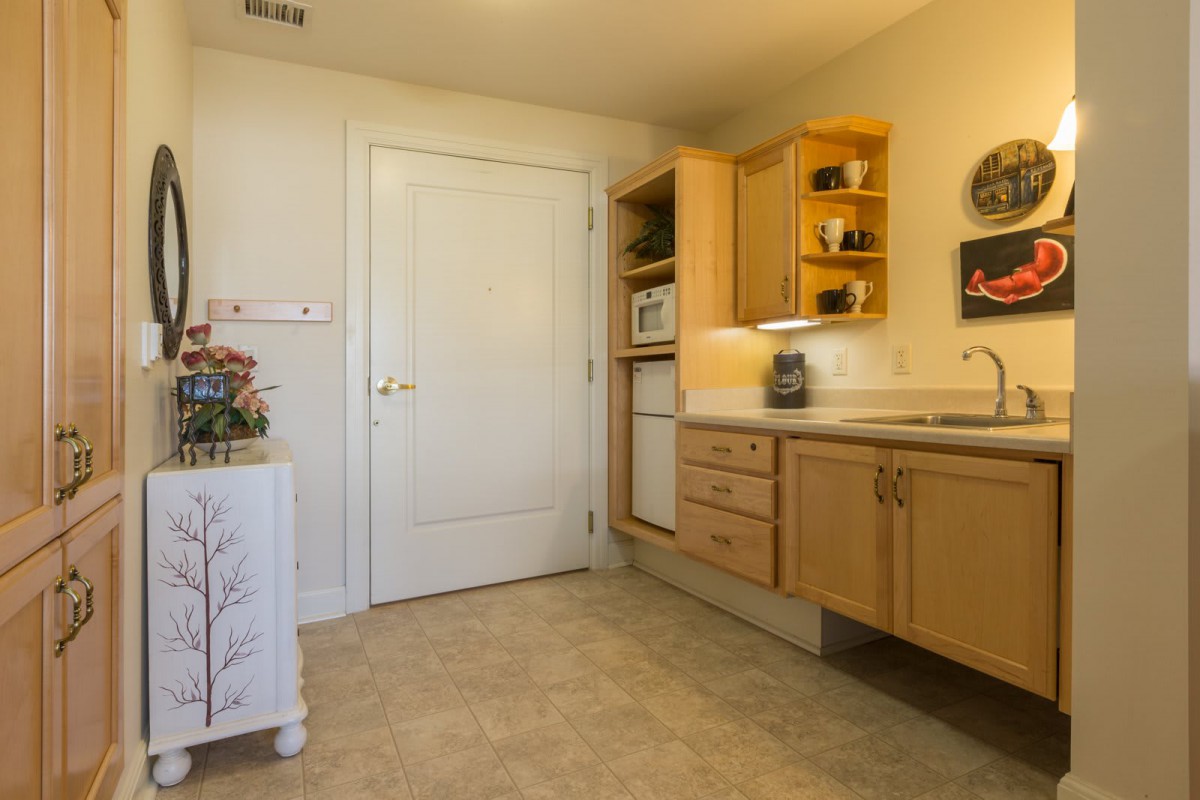 A cozy kitchen interior featuring wooden cabinets and a countertop with a microwave.