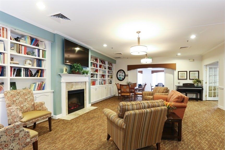 A cozy living room with a fireplace, bookshelves, and comfortable seating.