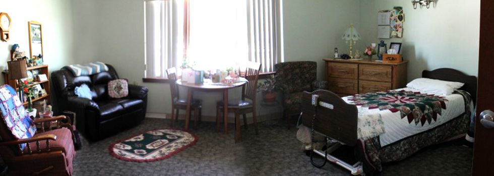 A cozy living room with a small table and chairs near a window.