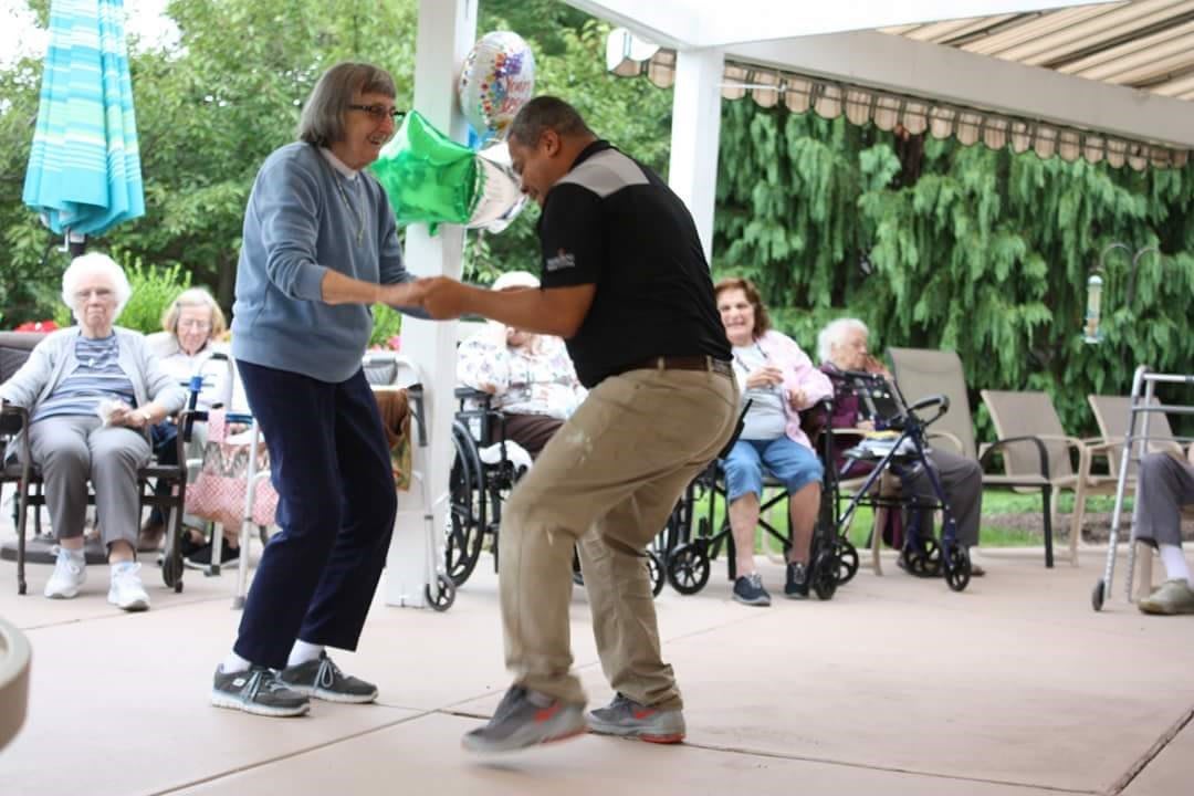 A lively outdoor dance between two people brings joy to an audience.