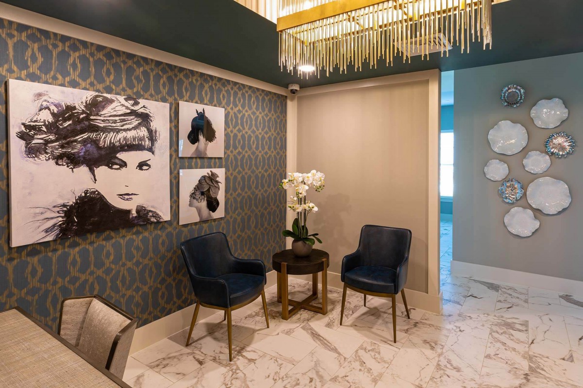 A modern and luxurious waiting area featuring stylish artwork, elegant chairs, and a marble floor.