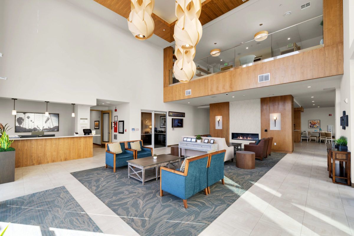 A spacious and modern lobby featuring comfortable seating, stylish lighting fixtures, and a welcoming atmosphere.