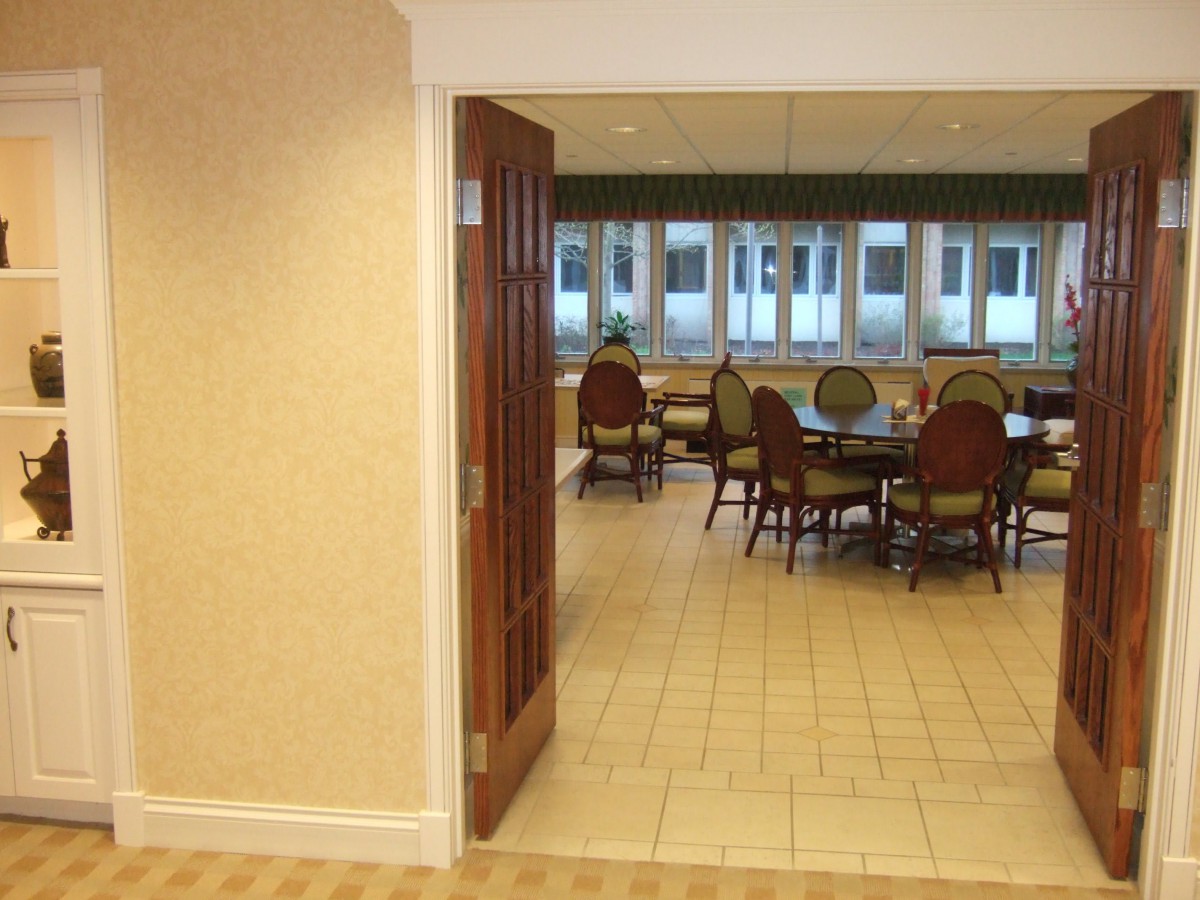 A view into a meeting room with chairs around a table and large windows.