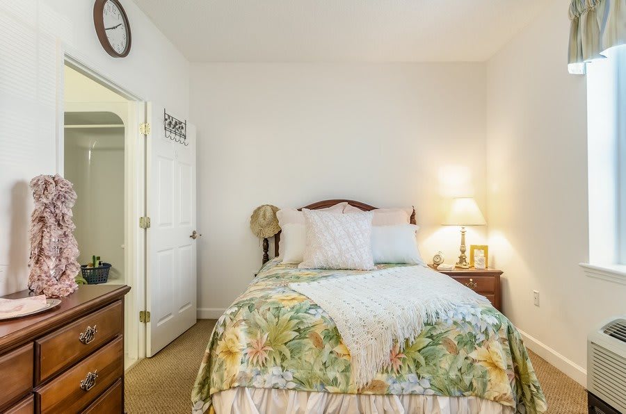A cozy bedroom with a neatly made bed and warm lighting.