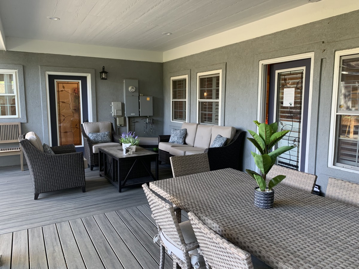 A cozy outdoor patio with comfortable seating and a table, ideal for relaxation.